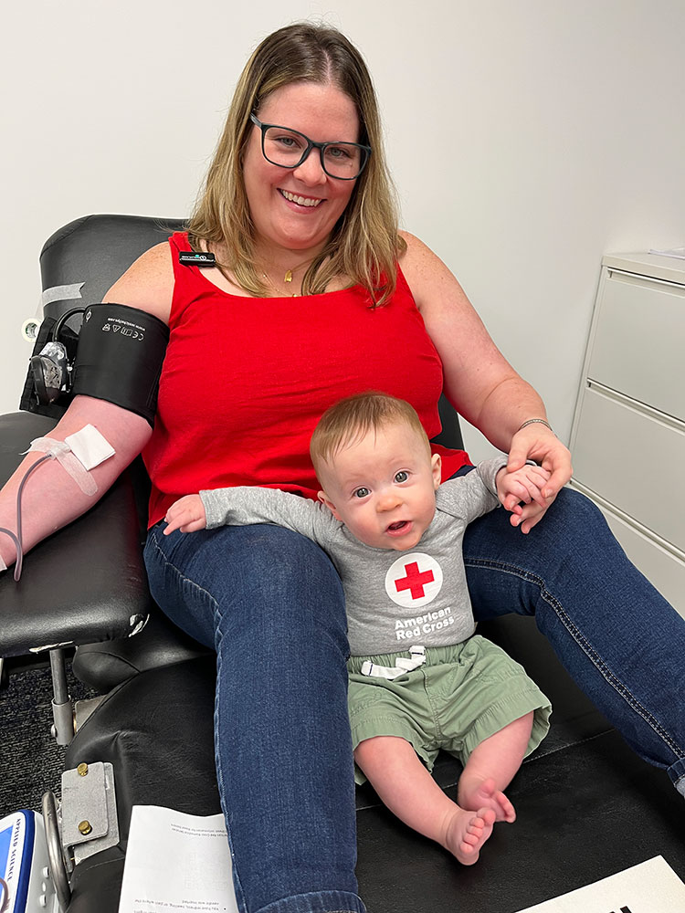 Morgan Cantrell and her baby Callum Oliver Cantrell-Bennett sitting in a blood donation chair and donating blood.