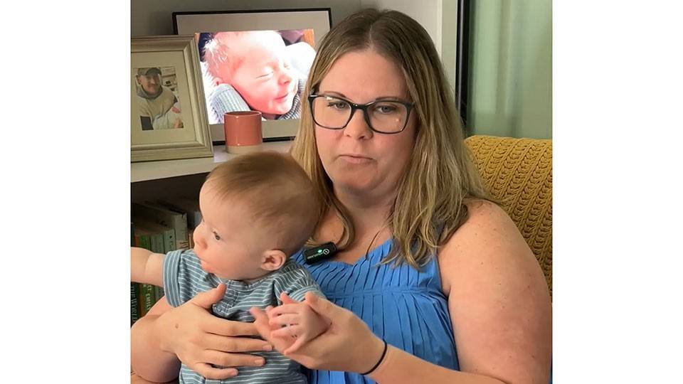 Morgan Cantrell sitting down and holding her baby.