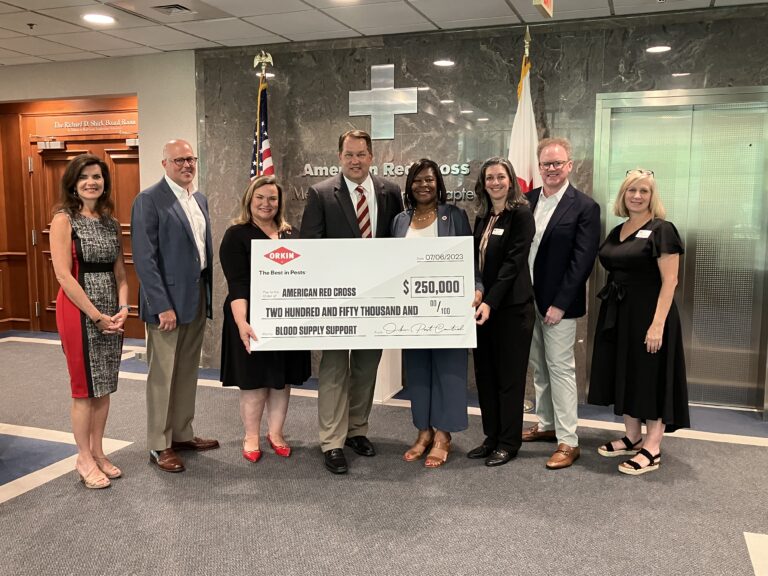 Orkin and red cross staff with donated check