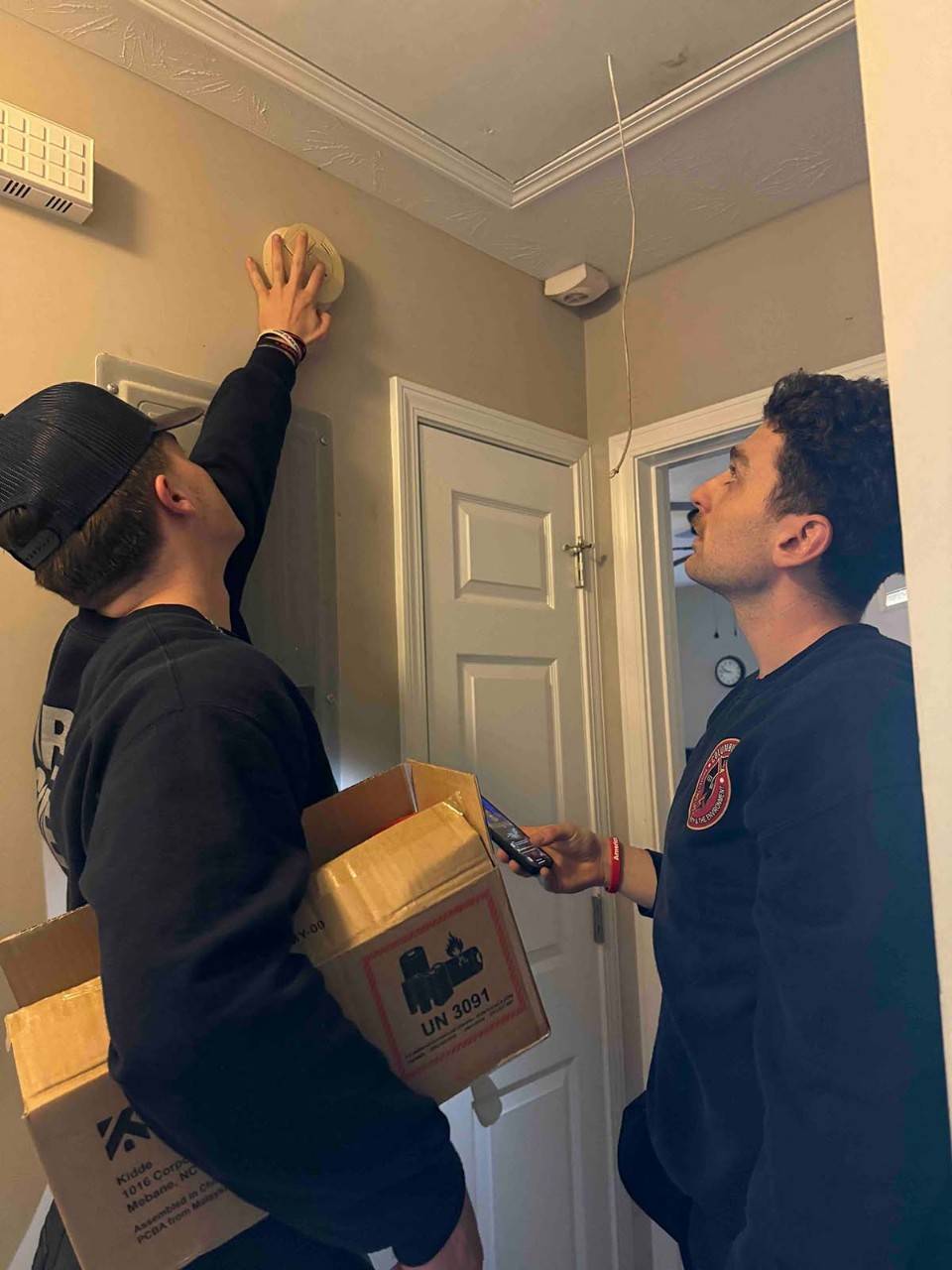 Jackson Singletary and Cole Smith, Columbus EMS, checking a smoke alarm