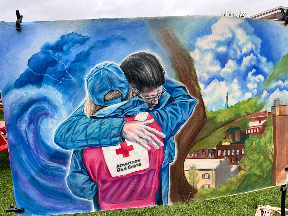 painting of a Red Cross volunteer embracing in a hug another person.