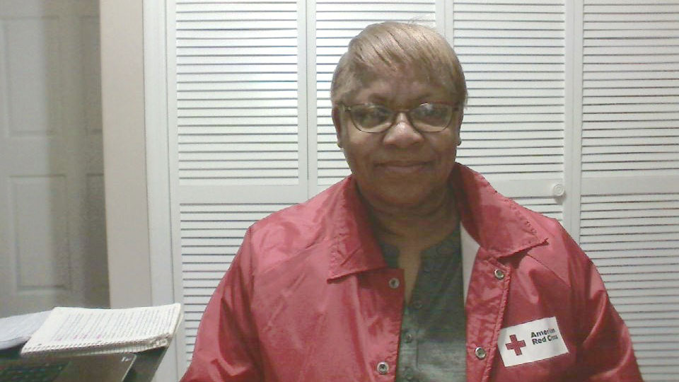 Stephanie Kelly wearing glasses and a Red Cross wind breaker.