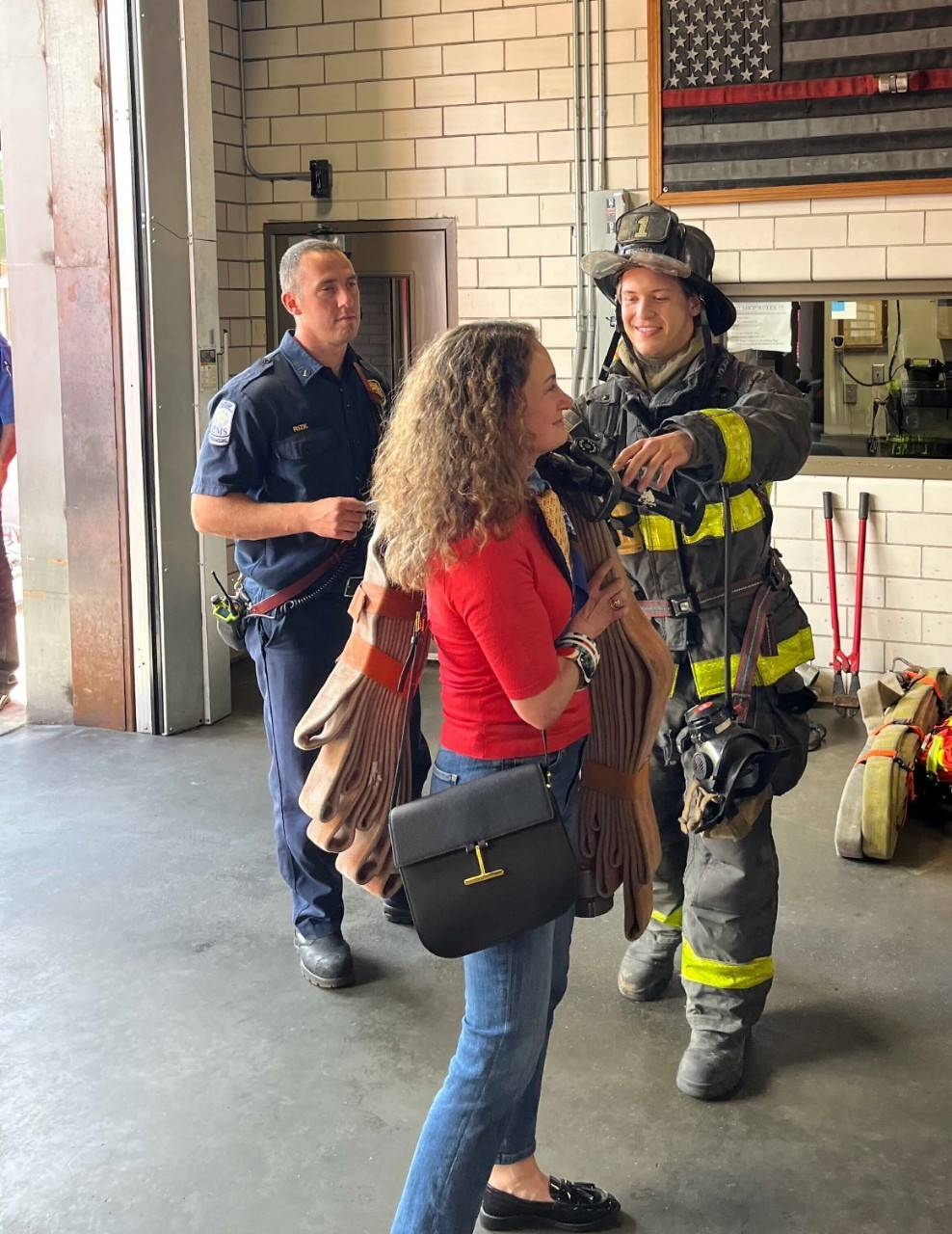 Volunteer Meredith Sidewater shoulders a length of fire hose
