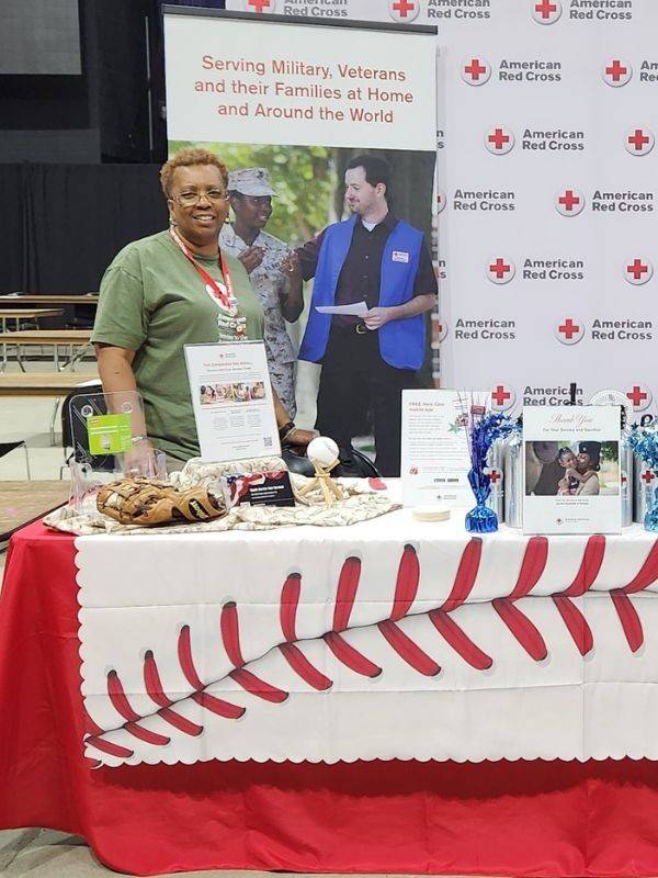 althea standing at red cross table booth