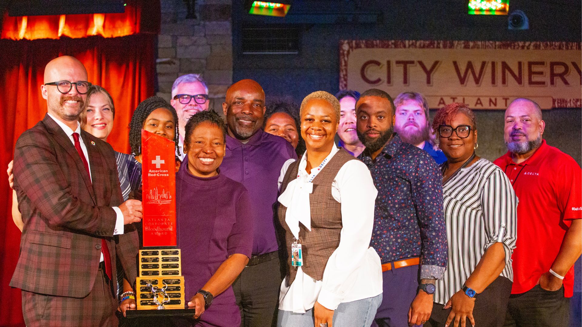 large group on stage holding award.