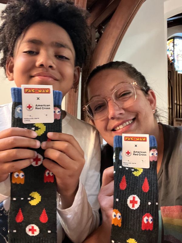 grayson and beth holding up red cross pacman socks