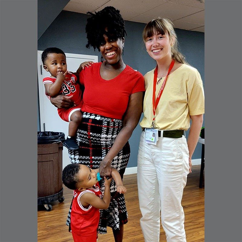 Red Cross volunteer with a mother and 2 children
