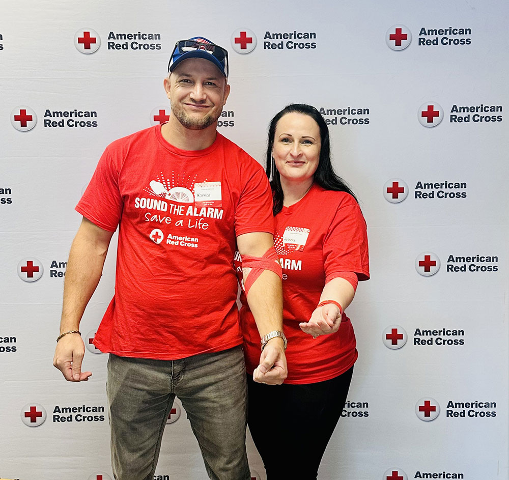 husband and wife show the bandages around their arm after donating blood.