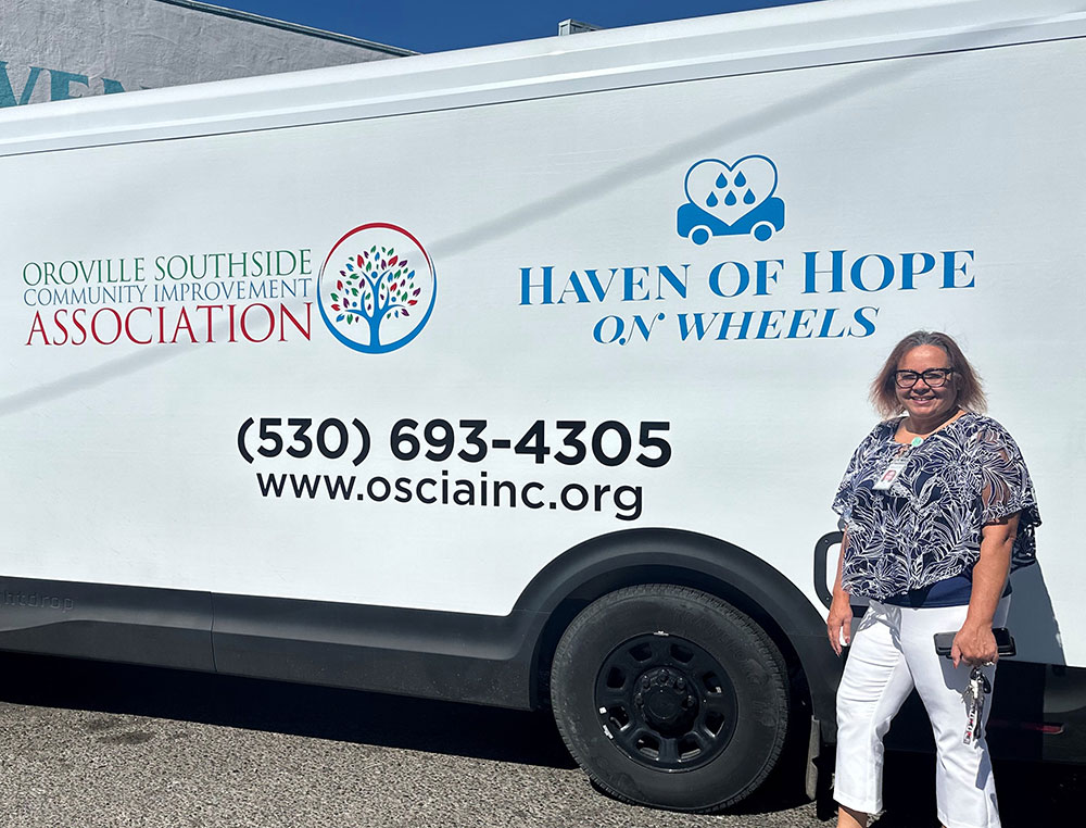 Lisa Torres standing next to the Haven of Hop on wheels van.