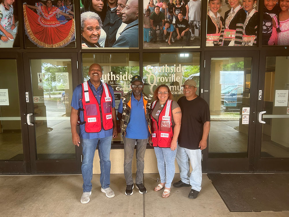 Lisa Torres and three of her colleagues in front of a building with glass doors.