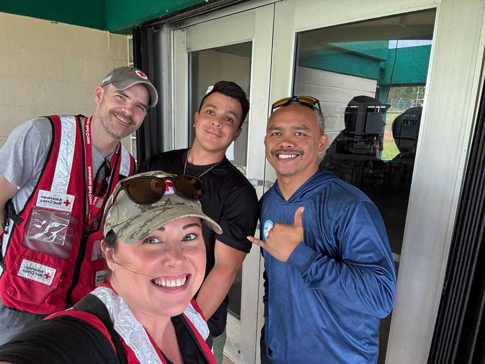 Caedy Minoletti, one Red Cross volunteer and two other people smiling for picture.
