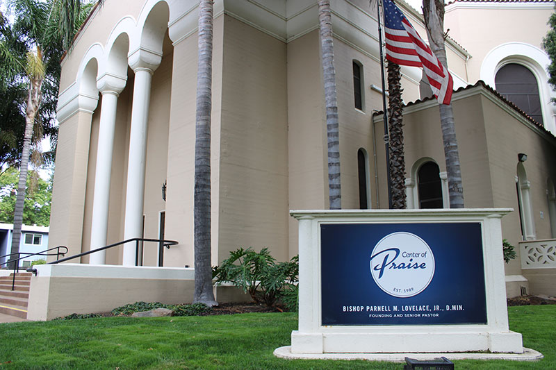 front of the center of praise building with building sign and american flag.
