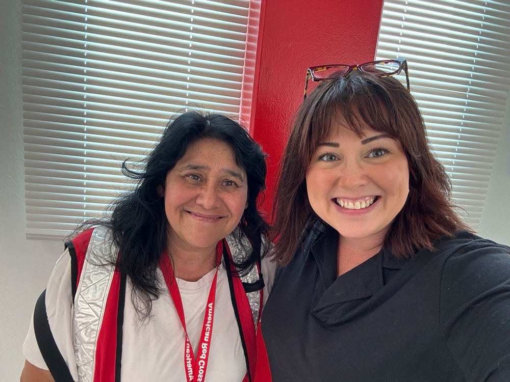 Caedy Minoletti and one Red Cross volunteers smiling for picture.