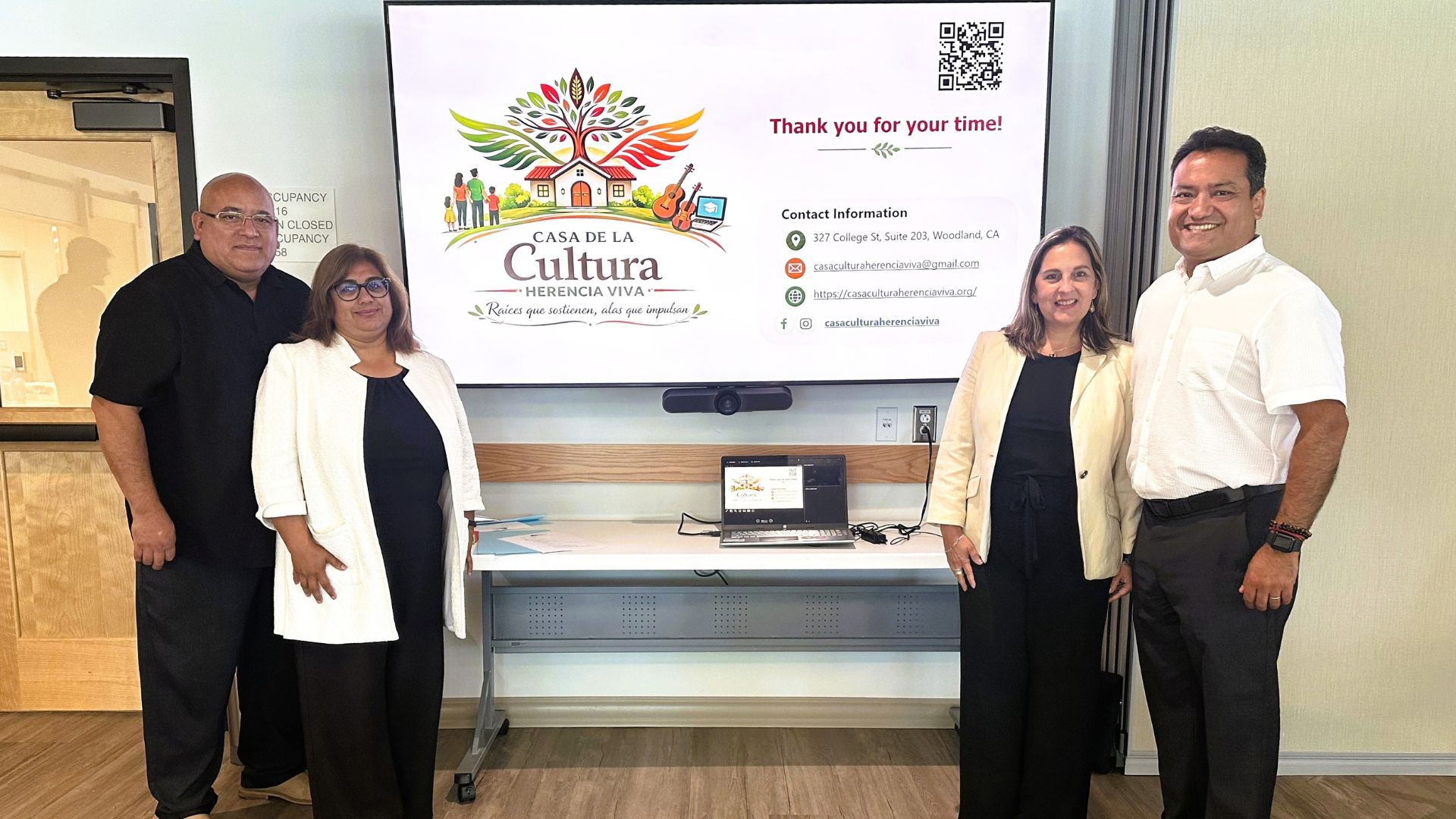 jaime and others stand in front of casa de la cultura presentation board