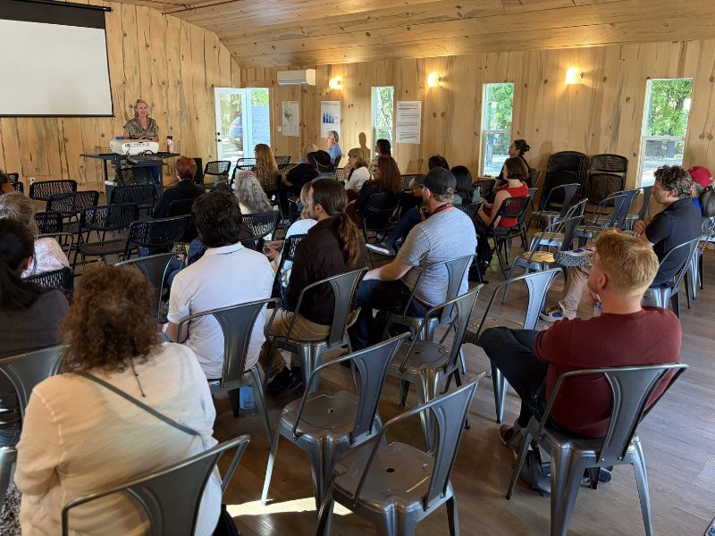 large group of people listening to presentation speakers