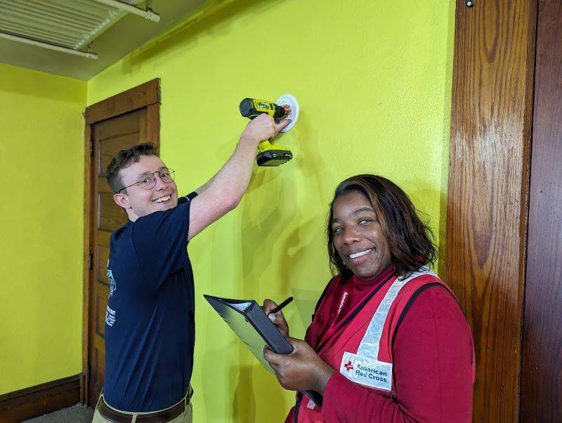 two volunteers installing a smoke alarm