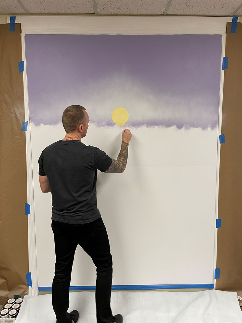 Person painting a mural.