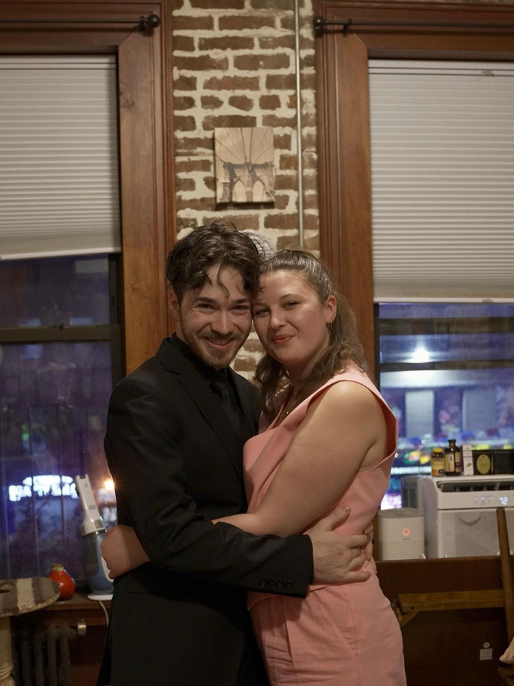 Aidan Samwick and Emily Trage pose together in their East Harlem apartment.