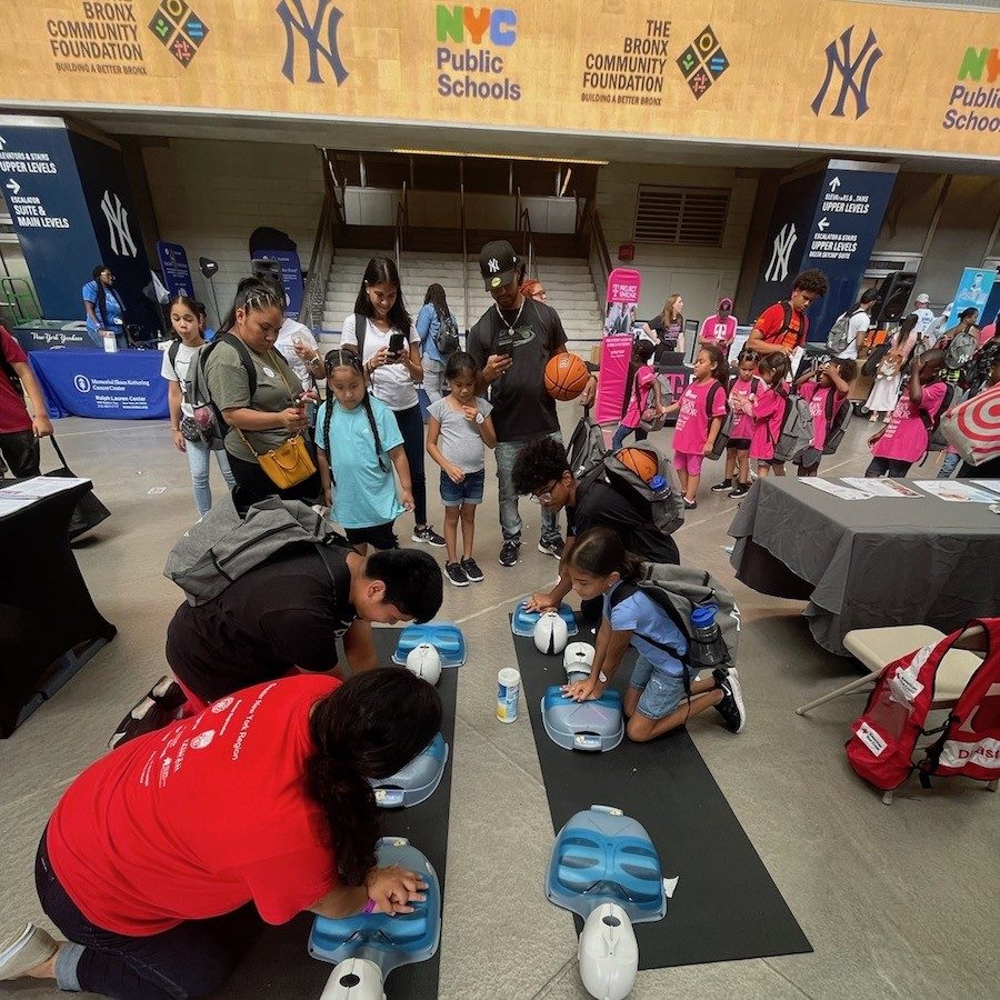 Students practicing hands-only CPR on practice mannequins