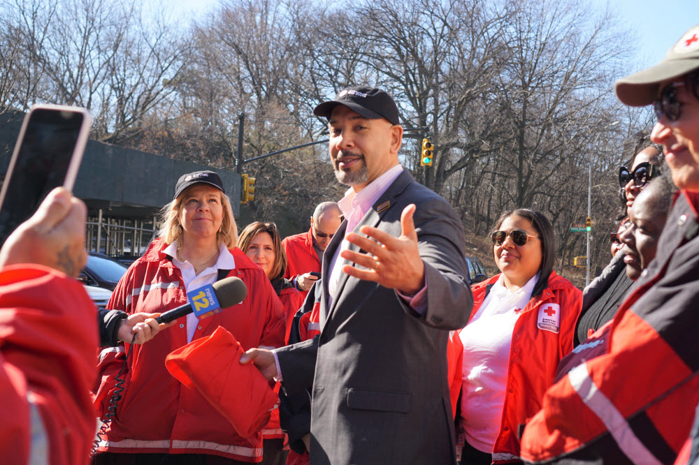 Ruben Diaz standing outside with several Red Cross volunteers wearing Red Cross jackets. 