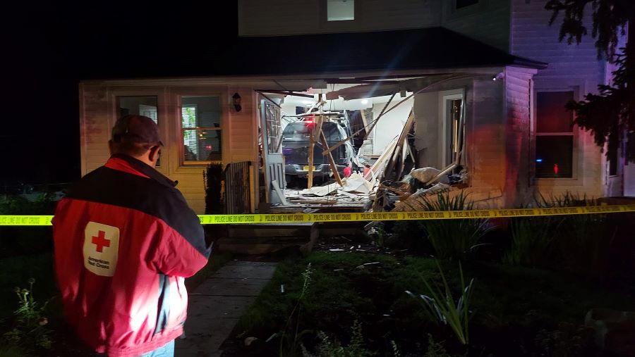 A Red Cross responder looks at the damage after a drunk driver crashed into Martha Richardson’s home in Huntington, NY.