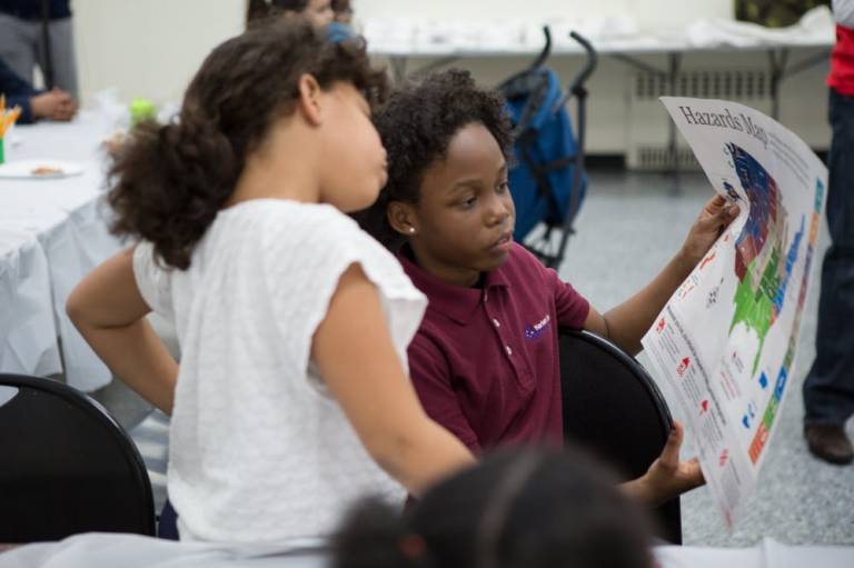 Two children reading over Red Cross preparedness map