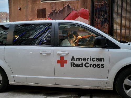 Red Cross staffers Elias Higgs and Norma Marcos look over the client intake list to determine how many hotel rooms are needed for displaced building residents.