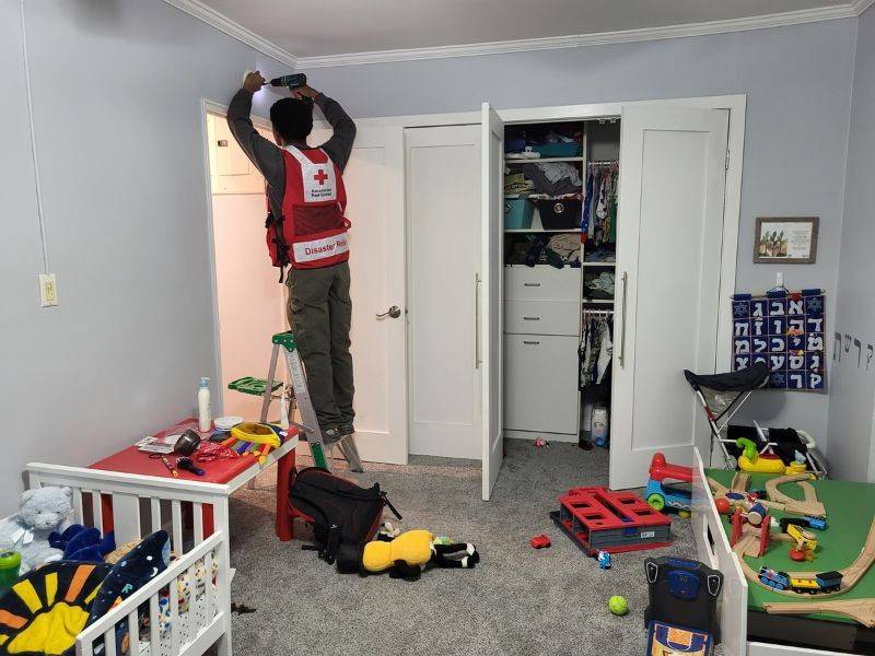 red cross volunteer installing alarm