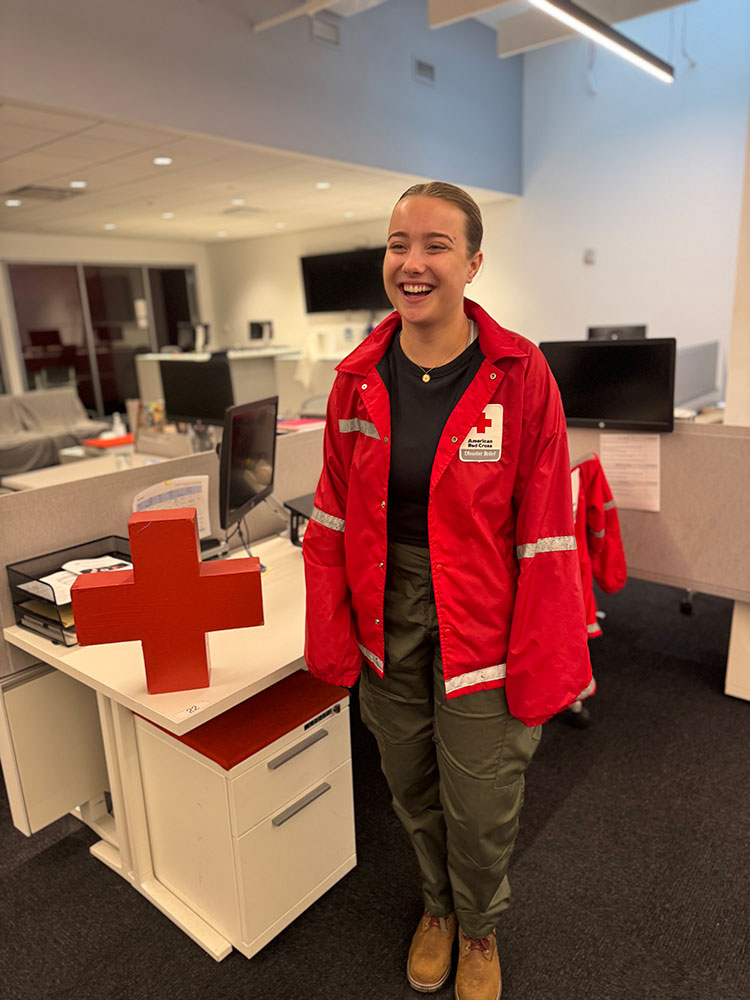 Olivia Haunso, wearing a Red Cross jacket, stands in the responder area at the Greater New York headquarters in midtown Manhattan.