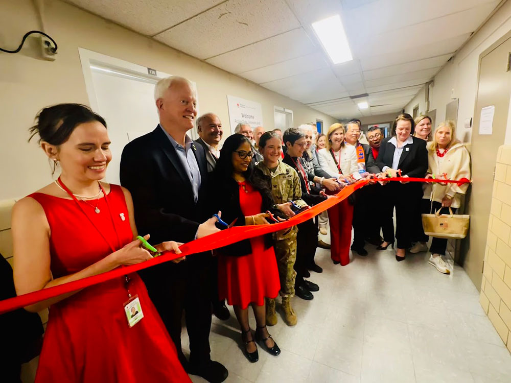 group of people in business clothes and one in military clothing, at a ribbon cutting ceremony.