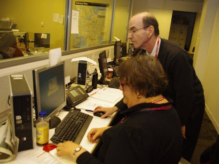 Richard Gallis helps a fellow Red Crosser on the computer in the Emergency Communications Center at the Greater New York headquarters.