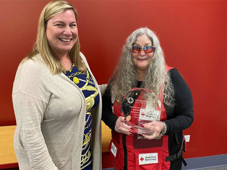 Tess Sheil holding the Clara Barton Honor Award she won, standing next to the Metro New York North CEO Stephanie Dunn Ashley.