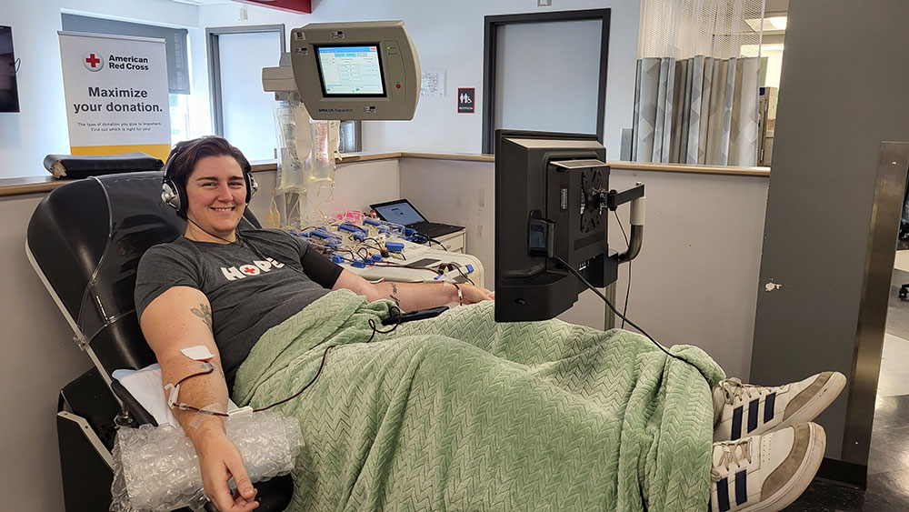 Graham Bridgeman sitting in a chair, with a blanket across his lap, donating platelets.