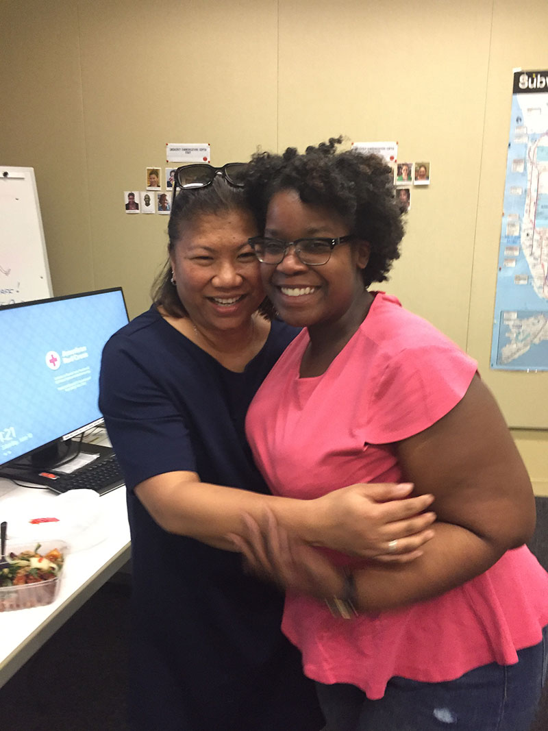 2 Red Cross employees smiling for camera