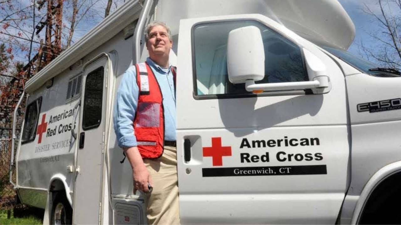 volunteer stepping out of red cross vehicle