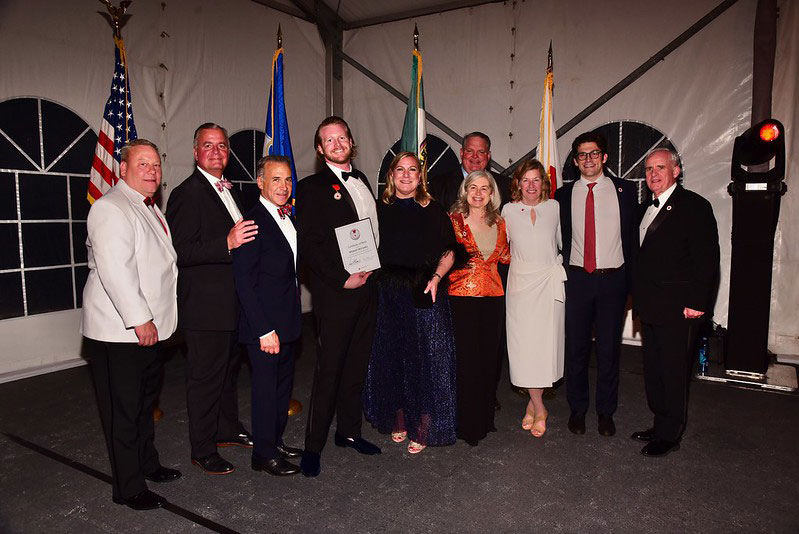 Michael McCauley, holding the American Red Cross Certificate of Merit during the Red & White Ball in April 2023