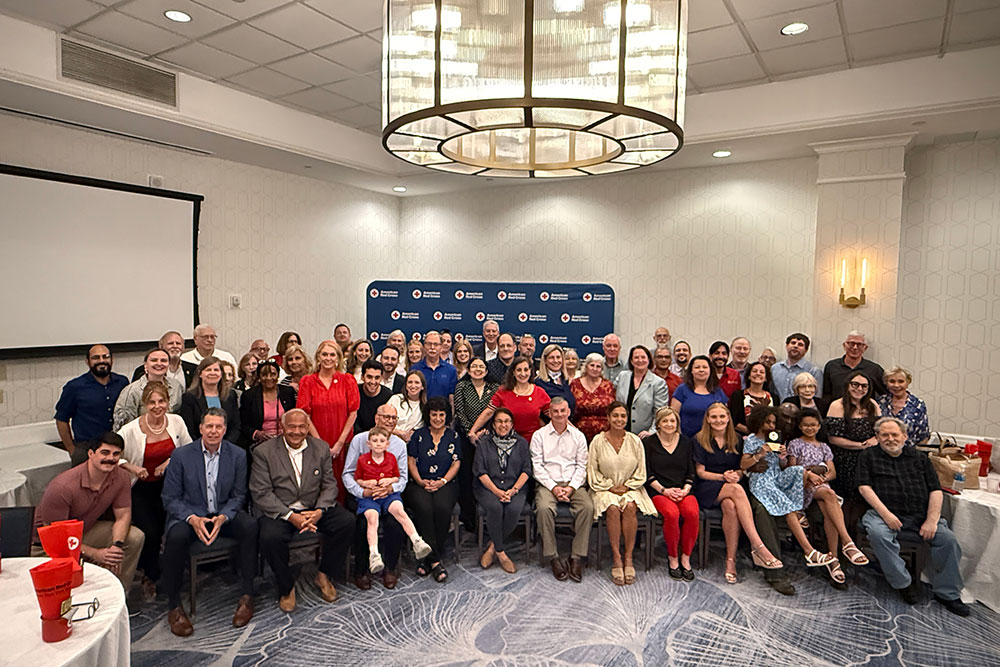 Group photo of the Metro New York North Chapter staff in a ballroom.