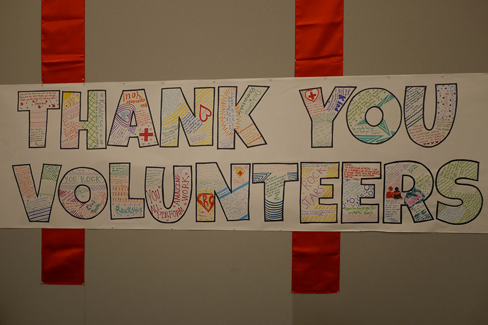 A hand drawn sign on the wall that says, "Thank You Volunteers."