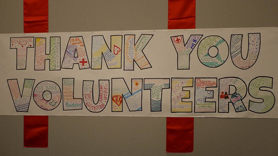 A hand drawn sign on the wall that says, "Thank You Volunteers."