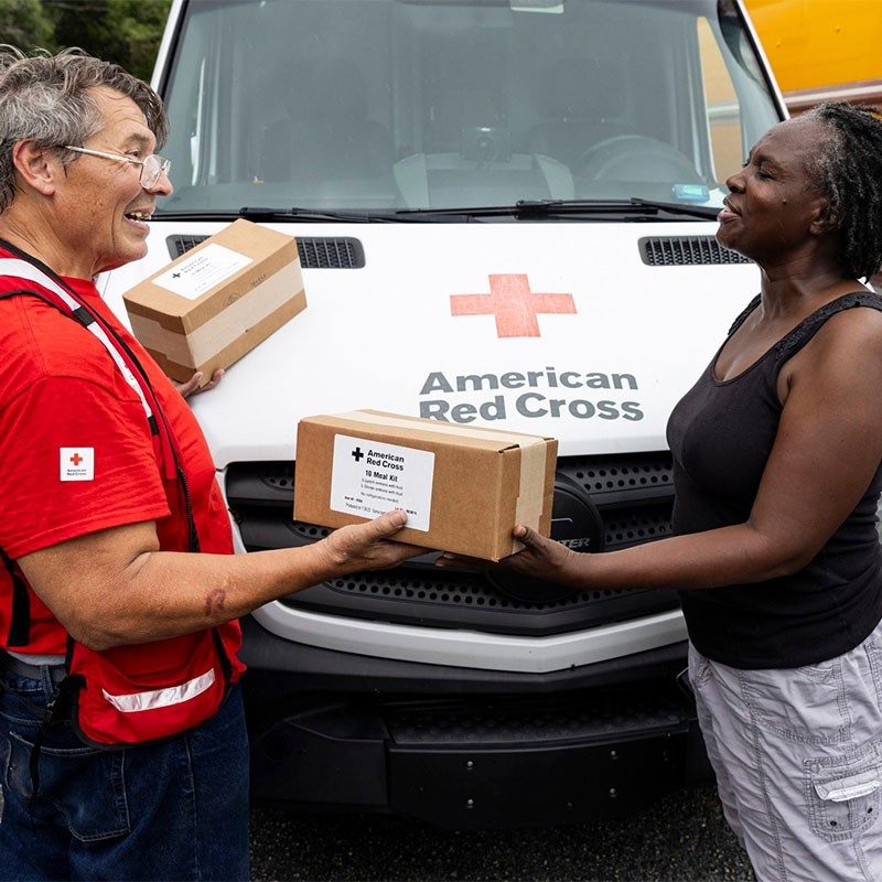 Don Klink handing out meals and supplies to lady