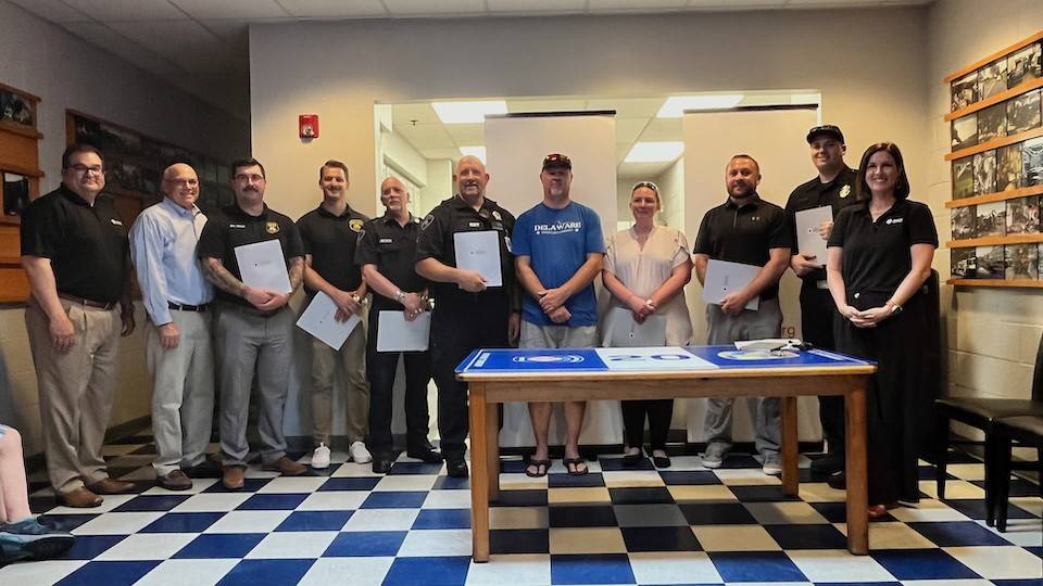 Stephen Funk, fire fighters and EMTs inside a building group shot.