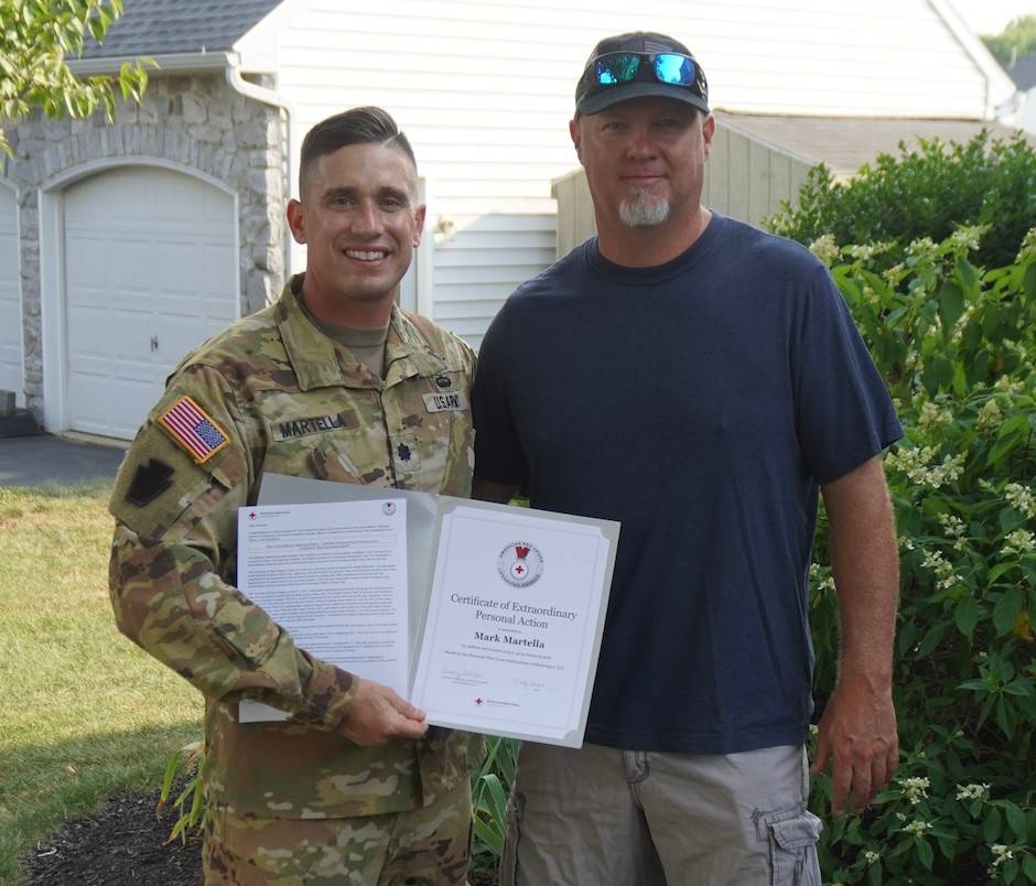 Stephen Funk and Lt. Col. Mark Martella in camo gear, holding American Red Cross Lifesaving Award.