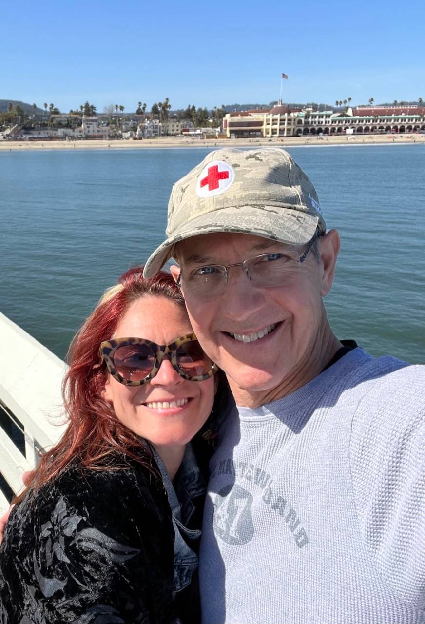Kat Walsh and Rich Byam smile on a pier in California.