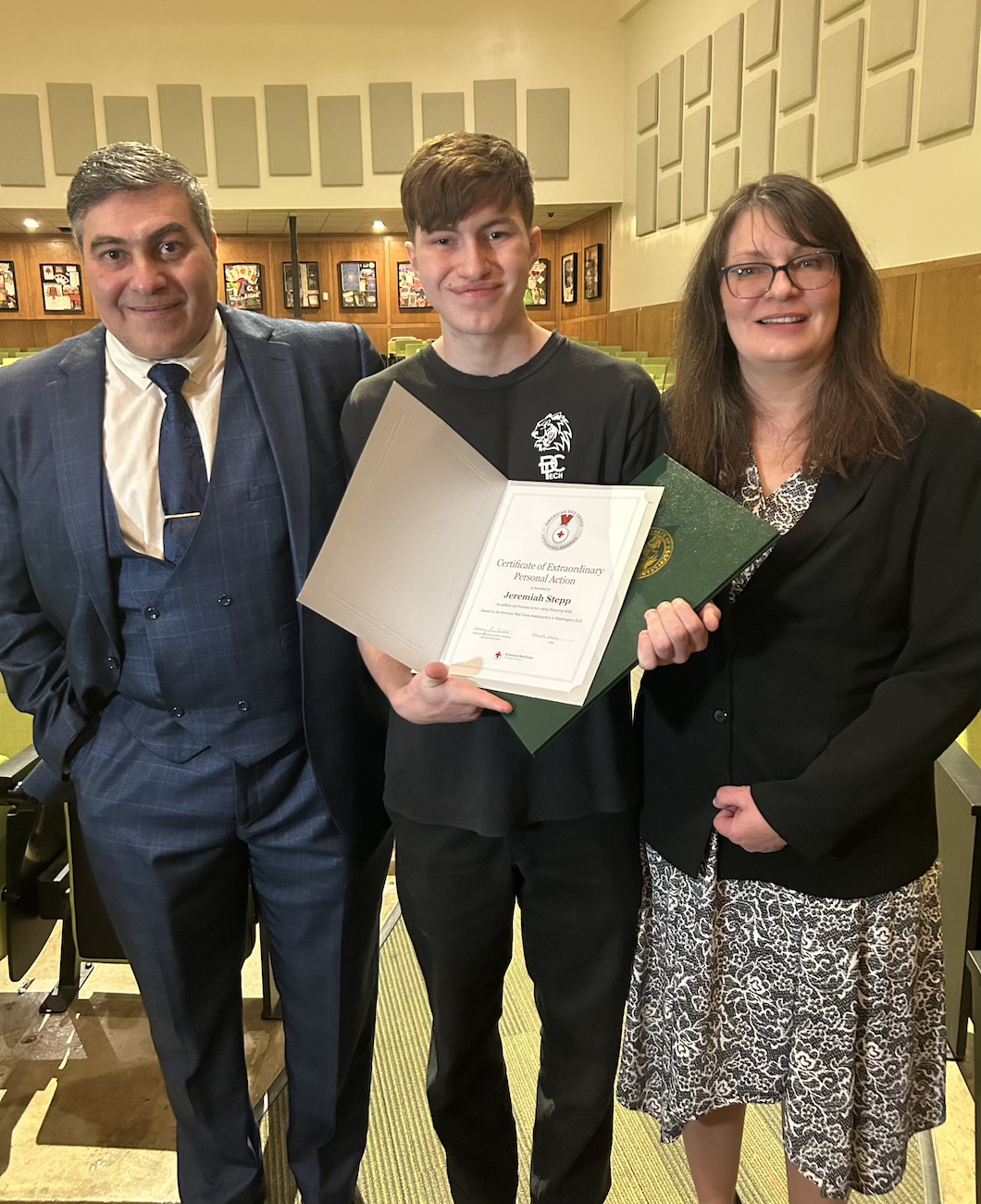 Michael Stepp, Jeremiah Stepp and Elizabeth Stepp pose with the American Red Cross Lifesaving Award, Certificate of Extraordinary Personal Action.