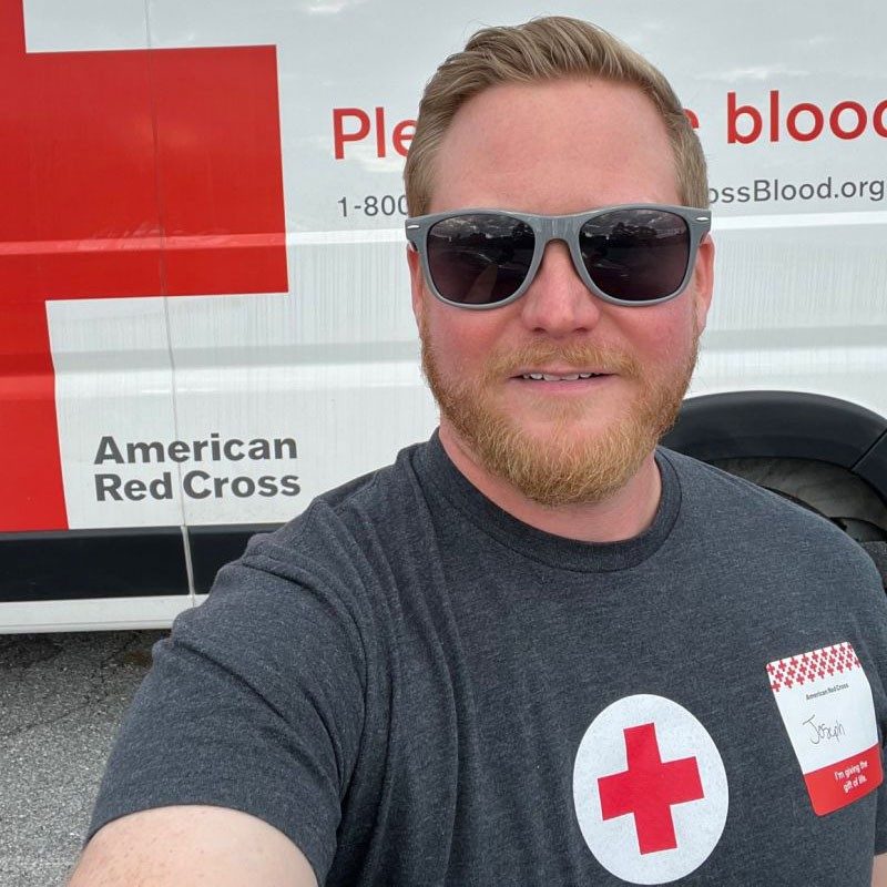 Joseph Tertel wearing Red Cross shirt in from of Red Cross van