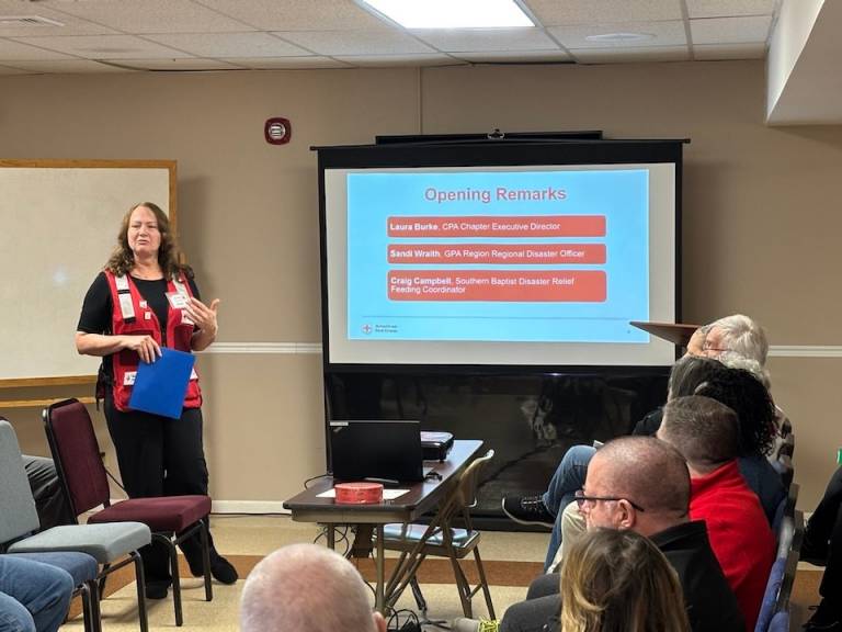 Woman speaks to volunteers and community partners about disaster relief