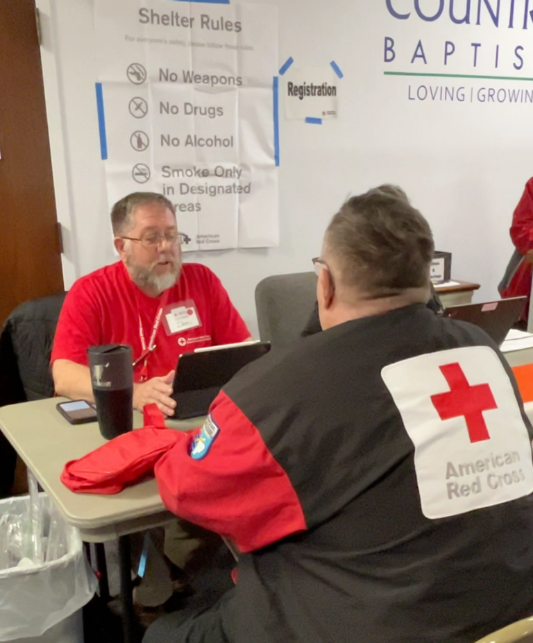 Red Cross volunteers work on registering people into emergency shelter