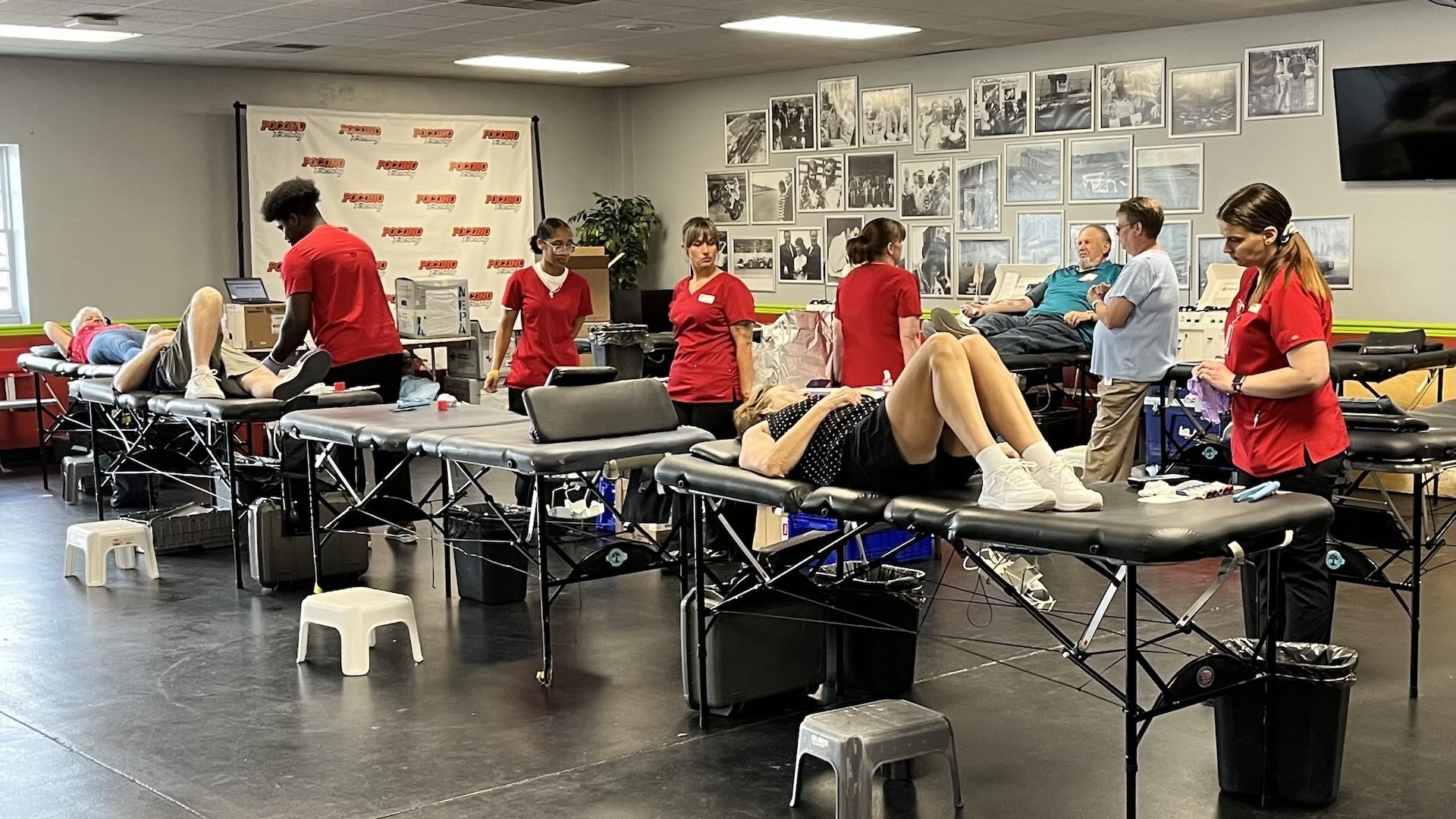 Blood donors lie down on beds as Red Cross staff assist them at Pocono Raceway Blood Drive event.
