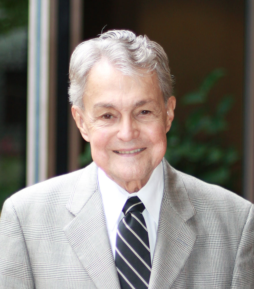 Dr. John Henry Felix in suit and tie.