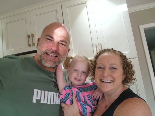 Emi and her parents smiling before treatment.